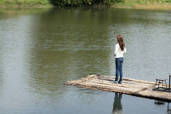 Woman on a bamboo raft in river — Stock Photo, Image