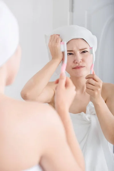 Mutsuz kadın bathro içinde ayna ile diş fırçalama banyo havlusu — Stok fotoğraf