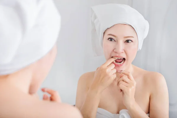 女人用牙线白色健康用在浴室的镜子 — 图库照片
