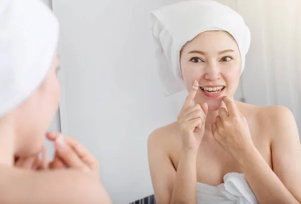 Donna usa filo interdentale bianco sano con specchio in bagno — Foto Stock