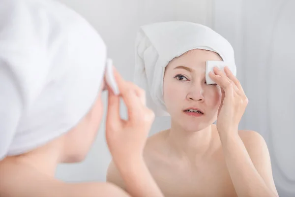 Ayna görünümlü ve yüzünü pamuk ile temizlik kadın — Stok fotoğraf
