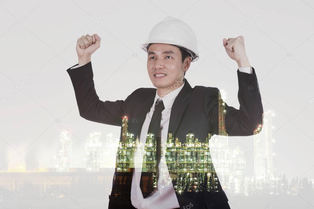 Double exposure of  engineer celebrating with arm raised against