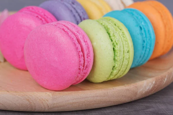 Dulce pastel colorido macaron en plato en mesa de madera — Foto de Stock