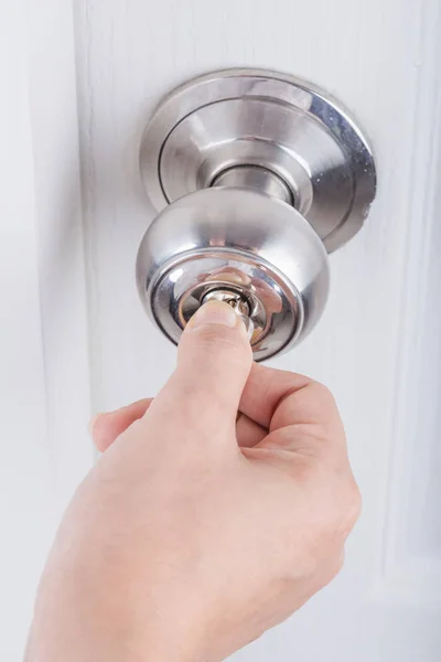 Hand use the key for unlocking door knob on white door — Stock Photo, Image