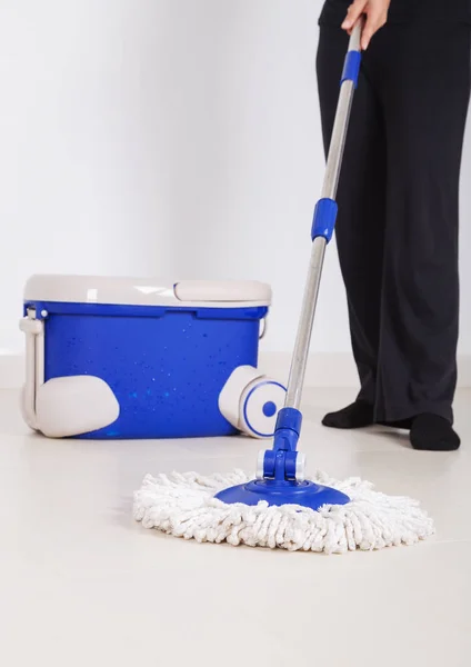 Pernas de mulher com esfregão e um balde de limpeza chão — Fotografia de Stock