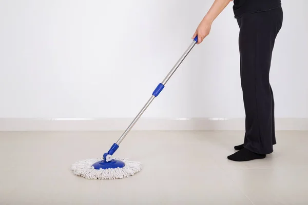 De benen van de vrouw met reiniging van de vloer dweilen — Stockfoto