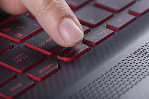 Dedo empurrando excluir botão no teclado do computador portátil — Fotografia de Stock