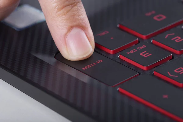 Palcem naciskając przycisk enter na klawiaturze laptopa — Zdjęcie stockowe