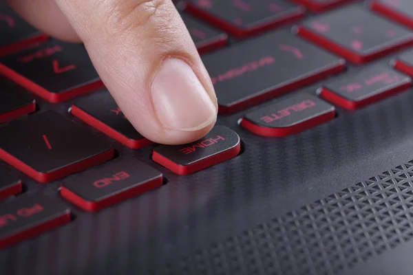 Dedo empurrando a tecla home no teclado do computador portátil — Fotografia de Stock