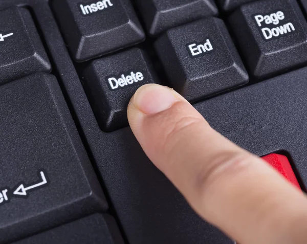 Prstem tlačí Odstranit tlačítko na klávesnici počítače — Stock fotografie