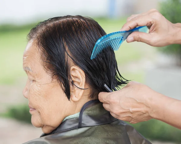 Hand use comb to dressing the hair of a senior woman — Stock Photo, Image