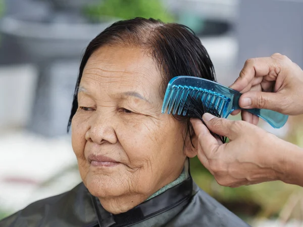 hand use comb to dressing hair of a senior woman