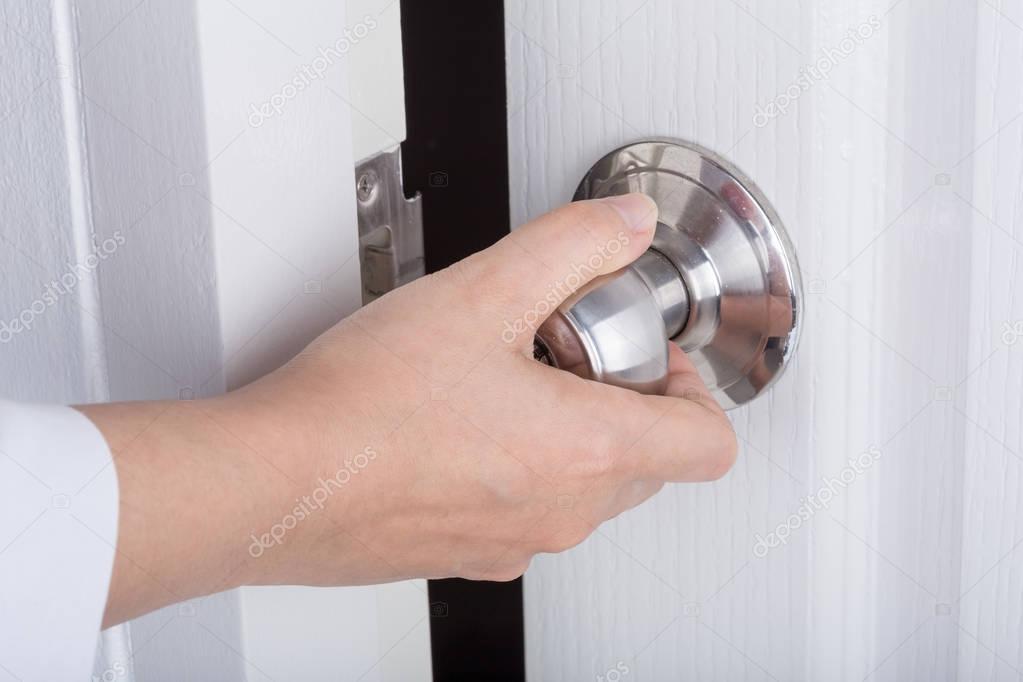 Hand opening door knob on white door — Stock Photo © geargodz 149393860
