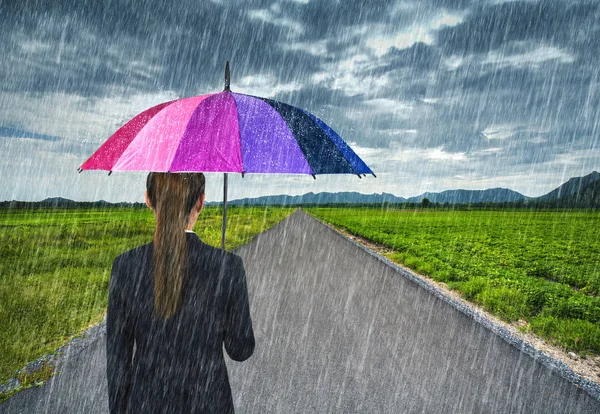 Επιχειρήσεων γυναίκα κρατώντας ομπρέλα με βροχή που πέφτει στο χώρα roa — Φωτογραφία Αρχείου