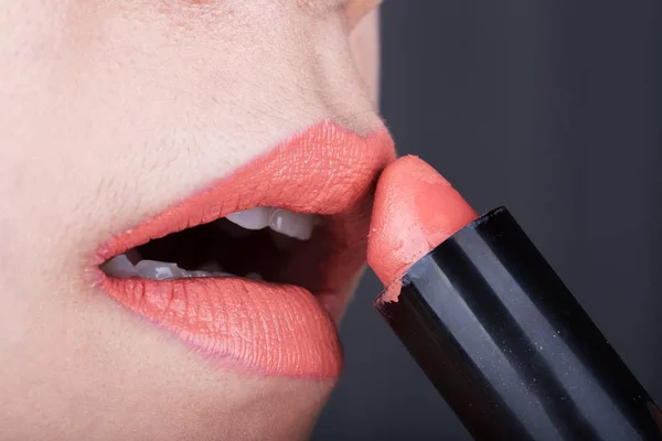 Γυναίκα εφαρμογή πορτοκαλί κραγιόν στα χείλη της — Φωτογραφία Αρχείου
