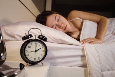 Saat 2 yönünde ve yatakta uyuyan kadın saati göster 