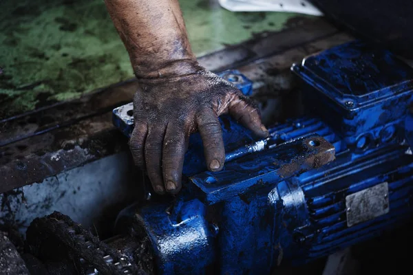 Mão do reparador durante o trabalho de manutenção do motor elétrico — Fotografia de Stock