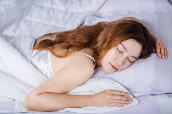 Kvinna som sover på säng i sovrummet — Stockfoto