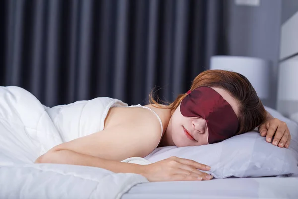 Woman sleeping on bed with eye mask — Stock Photo, Image