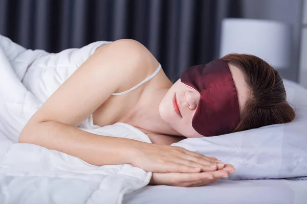 Woman sleeping on bed with eye mask — Stock Photo, Image