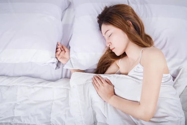 Mujer durmiendo en la cama en el dormitorio — Foto de Stock