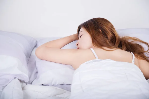 Woman sleeping on bed in bedroom — Stock Photo, Image