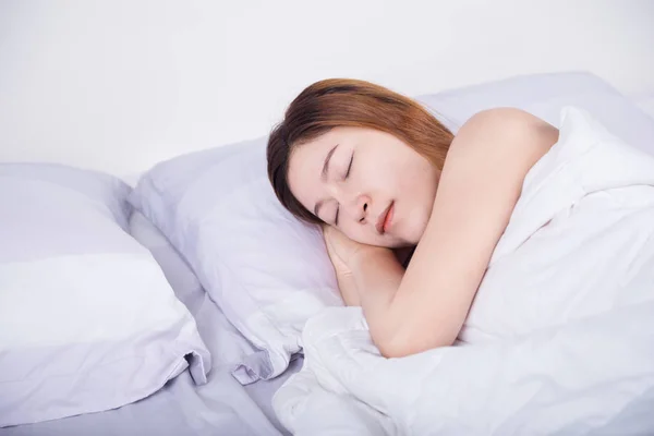 Woman sleeping on bed in bedroom — Stock Photo, Image