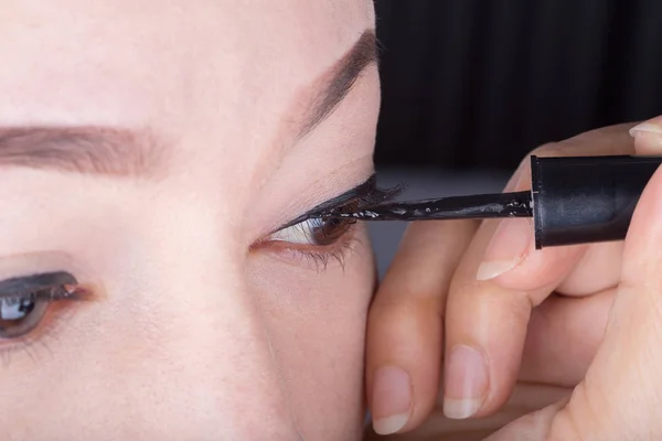 Maquillaje de mujer con delineador de ojos negro — Foto de Stock