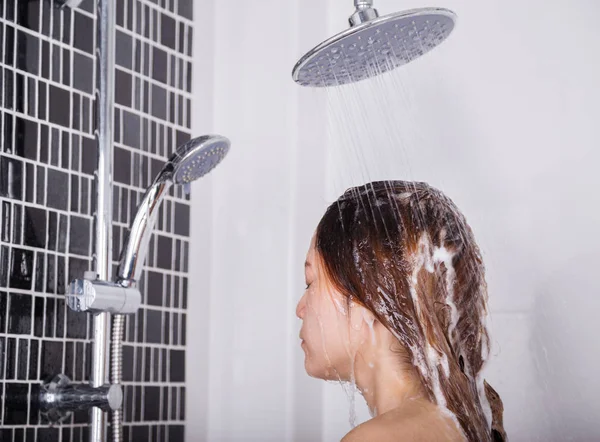 Mulher lavar a cabeça e o cabelo no chuveiro chuva por shampoo — Fotografia de Stock