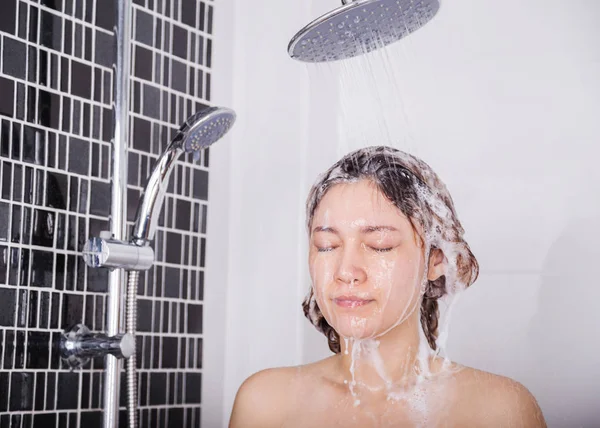 Mulher lavar a cabeça e o cabelo no chuveiro chuva por shampoo — Fotografia de Stock