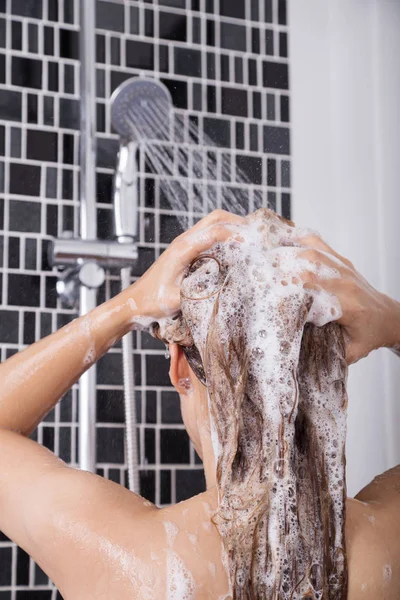 Femme se laver la tête et les cheveux sous la douche par shampooing, vue arrière — Photo