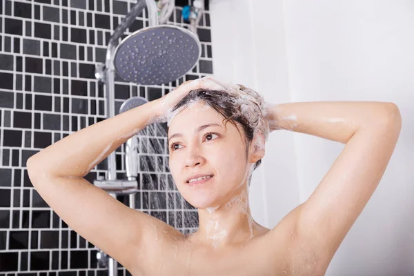 Mulher feliz cabeça de lavagem com shampoo e chuveiro — Fotografia de Stock