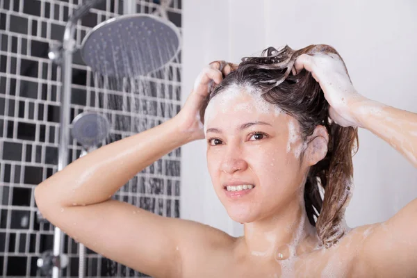 Mujer infeliz cabeza de lavado con champú y ducha —  Fotos de Stock