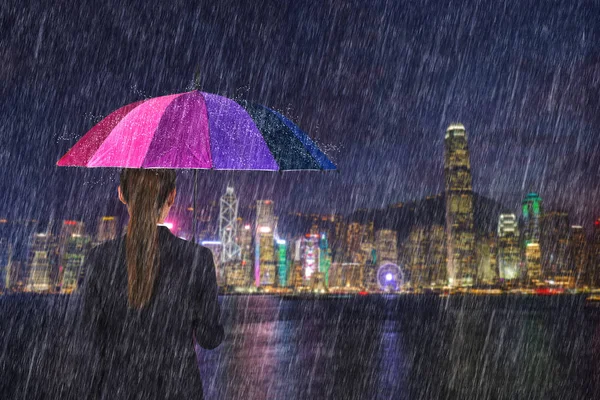 Mujer de negocios sosteniendo paraguas con lluvia cayendo en victoria ha — Foto de Stock