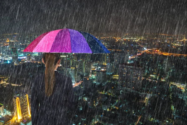 Femme d'affaires tenant parapluie multicolore avec chute de pluie a — Photo