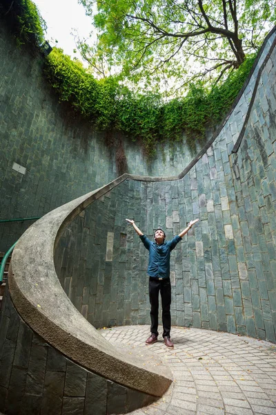 Homme mains en l'air dans un passage souterrain à Fort Canning Park, Singa — Photo