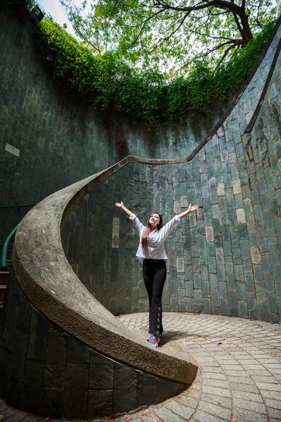 Femme mains en l'air dans un passage souterrain à Fort Canning Park, Sin — Photo