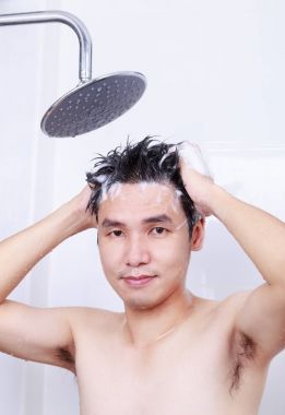 mutlu bir adam yağmur duş alıyor ve banyoda saç yıkama