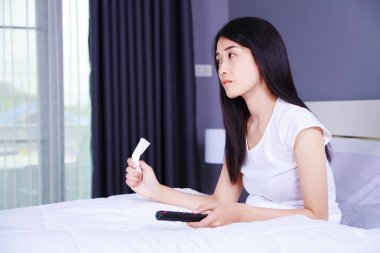 Uzaktan kumandalı yatak yatak odasında TV izlerken ağlayan kadın