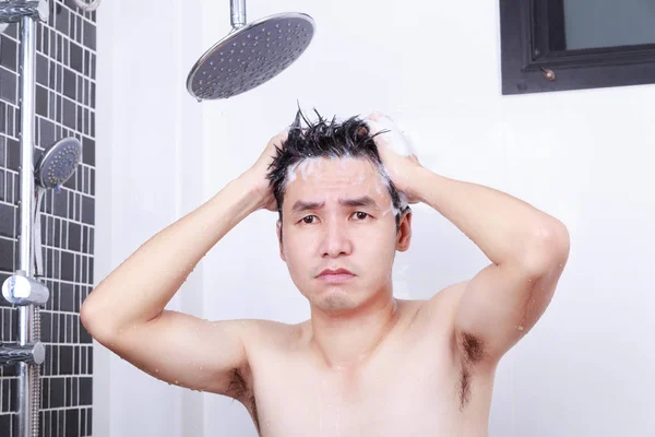 Nieszczęśliwi człowieka są biorąc prysznic ze strumieniem deszczowym i mycie włosów w każdym — Zdjęcie stockowe