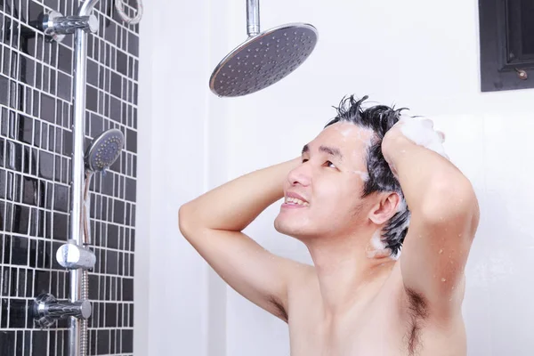 Szczęśliwy człowiek są biorąc prysznic ze strumieniem deszczowym i mycie włosów w łazience — Zdjęcie stockowe