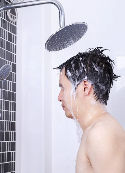 Homem estão tomando um banho de chuva e lavar o cabelo no banheiro — Fotografia de Stock