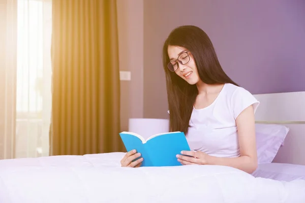Vrouw lezen van een boek op bed in de slaapkamer thuis — Stockfoto