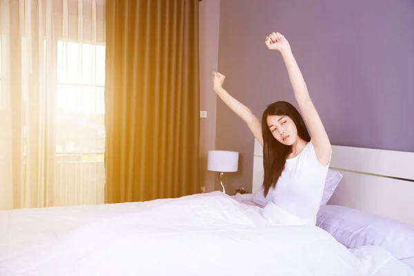 Vrouw wakker en hand die aan de orde gesteld op bed in de slaapkamer — Stockfoto
