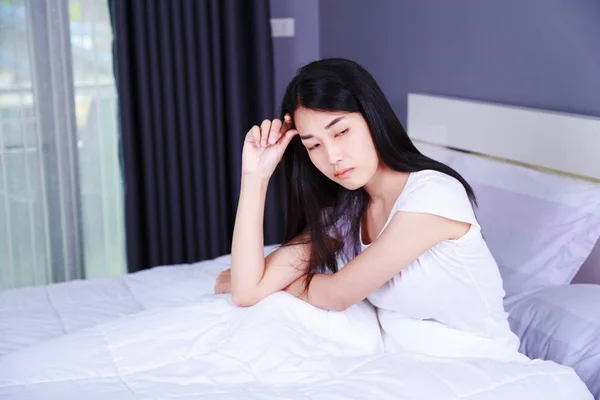 Mujer preocupada pensando en la cama en el dormitorio — Foto de Stock