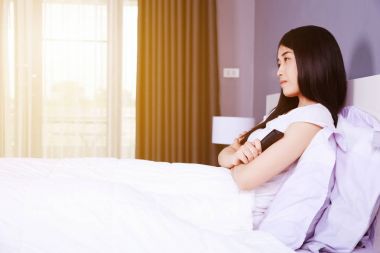 Uzaktan kumandalı yatak yatak odasında TV izlerken kadın