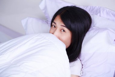 Kadın yatakta yatak odasında bir battaniyenin altında gizleme