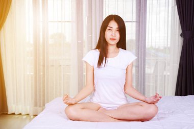 Kadının yatak yatak odasında Yoga egzersiz yapması