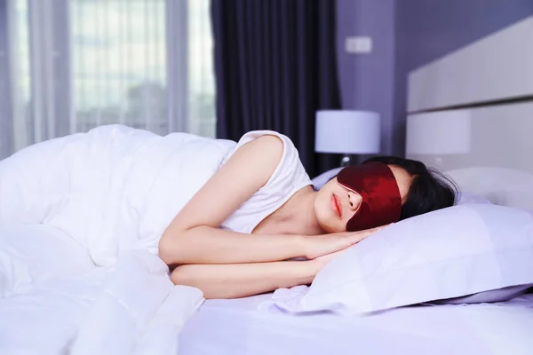 Kvinna som sover med eye mask på sängen i sovrummet — Stockfoto