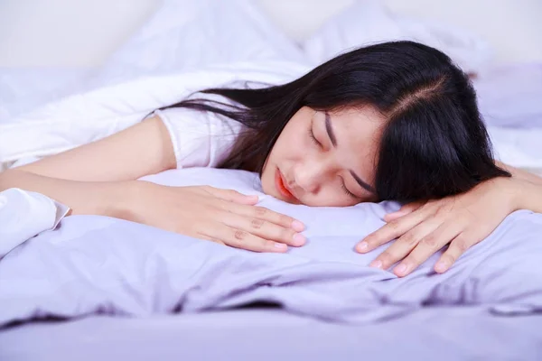 Mujer durmiendo en la cama en el dormitorio — Foto de Stock